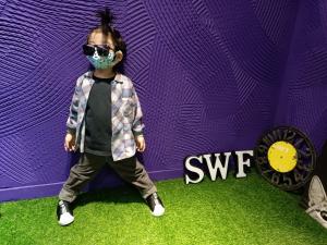 a young child wearing a face mask in front of a purple wall at SWF淡水新五福旅館 Sinwufu Hotel in Tamsui