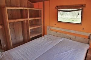 een slaapkamer met een bed en een raam en een raam bij Ijsmolenhoeve in Ronse
