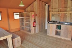 uma cozinha com paredes e pisos em madeira em Ijsmolenhoeve em Ronse