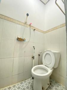 a bathroom with a white toilet in a room at Homestay Batu Kelir Syariah Dieng Mitra RedDoorz in Dieng