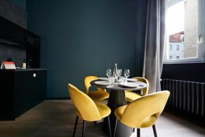 ein Esszimmer mit einem Tisch und gelben Stühlen in der Unterkunft numa l Sketch Rooms & Apartments in Berlin