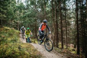 three people riding bikes on a trail in the woods at Seecamping Berghof - Mobilheime in Landskron +54 photos