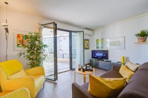sala de estar con sofá y TV en Appartement Liberation - Happy Rentals, en Niza