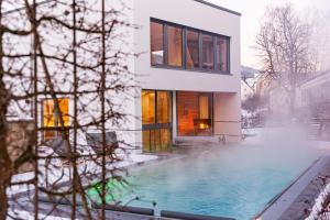 a house with a swimming pool in the snow at Hotel St. Florian in Frauenau
