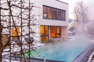 ein Haus mit Pool im Schnee in der Unterkunft Hotel St. Florian in Frauenau