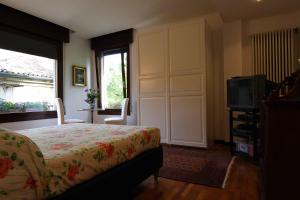 sypialnia z łóżkiem, telewizorem i oknem w obiekcie B&B Al Duomo w Padwie