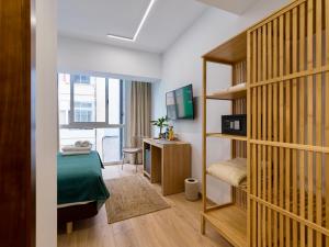 a bedroom with a bed and a desk and a television at Hotel Emeté & Coworking in Las Palmas de Gran Canaria