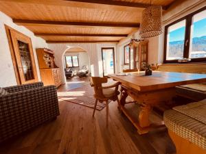 a living room with a wooden table and a couch at Landhaus am Schneewittchenberg in Sonthofen