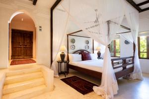 a bedroom with a bed with a canopy at Qambani Luxury Resort in Michamvi +37 photos