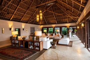 a living room with white furniture and a large ceiling at Qambani Luxury Resort in Michamvi