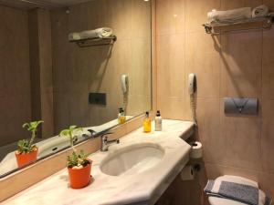 un bagno con lavandino e specchio di Caravel Hotel Apartments a Ixiá
