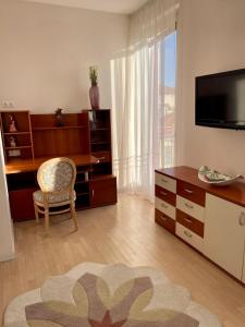 CENTRAL LOFT في فاريزي: غرفة معيشة مع تلفزيون ومكتب وكرسي