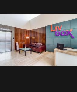 - un salon avec un canapé et une table dans l'établissement Hotel Livbox, à Dehradun