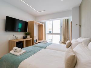 een hotelkamer met twee bedden en een flatscreen-tv bij Hotel Emeté & Coworking by Airnest in Las Palmas de Gran Canaria