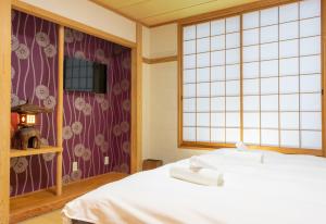 小谷村T Square Hakuba的带白色床和窗户的卧室