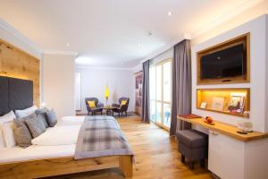 a hotel room with a bed and a table and chairs at Hotel St. Florian in Frauenau