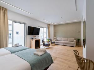 a bedroom with a large bed and a living room at Hotel Emeté & Coworking in Las Palmas de Gran Canaria