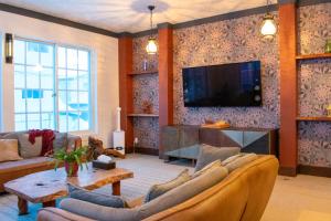 a living room with a couch and a tv on a wall at T Square Hakuba in Otari