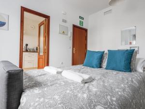 1 dormitorio con 1 cama grande con almohadas azules en Alcalá del rio! 2 a en Alcalá del Río