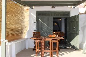 una mesa y sillas en un patio con una puerta verde en Manis Sirma (fisherman's house by the Sea) en Provatas