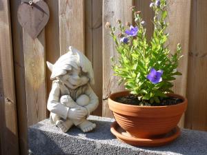 a statue of a bunny sitting next to a potted plant at FeWo Ostseestrand in Neustadt in Holstein