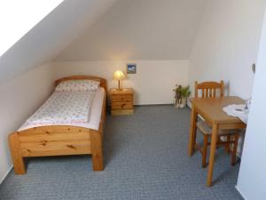 1 dormitorio con cama, escritorio y mesa en FeWo Ostseestrand, en Neustadt in Holstein