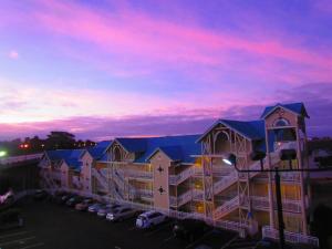 ein Gebäude mit einem Parkplatz vor einem Sonnenuntergang in der Unterkunft North Cliff Hotel in Fort Bragg