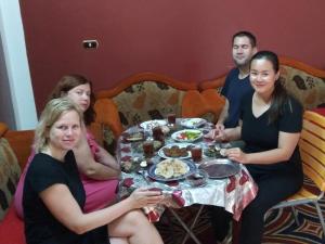 a group of people sitting around a table with food at Labib Guest House in Aswan