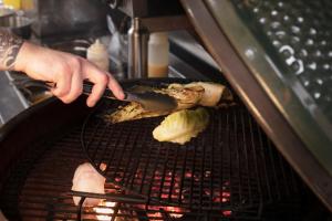 a person is cooking food on a grill at Lagom Restaurant & Townhouse in Kenmare