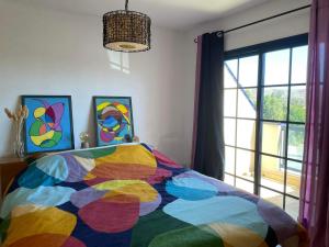 a colorful bed in a bedroom with a window at MiRA MAR in Lajita