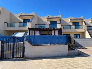 a building with a blue fence in front of it at MiRA MAR in Lajita
