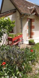 a red wagon in front of a house with flowers at Le Petit Pavillon in Cheverny