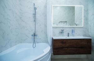 a white bathroom with a tub and a sink at Zolotoy Kolos in Moscow