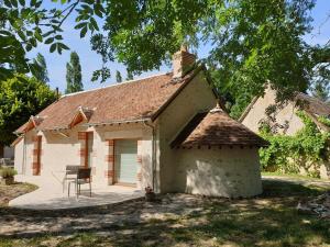 un cottage con tavolo e sedia in cortile di Le Petit Pavillon a Cheverny