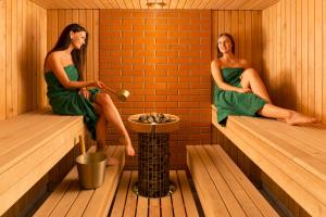 Deux femmes sont assises dans un sauna dans l'établissement Sagadi Manor Hotel, à Sagadi