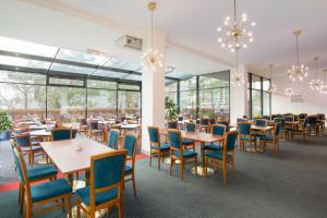 a dining room with tables and chairs and windows at Hotel ILF in Prague