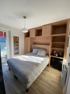 um quarto com uma cama grande e prateleiras de madeira em Hôtel-restaurant La bonne hôtesse em Chambon-sur-Lac
