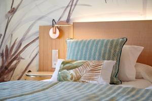 a bedroom with a bed with a headboard and pillows at Grupotel Parc Natural & Spa in Playa de Muro