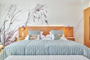 a bedroom with a large bed with a blue comforter at Grupotel Parc Natural & Spa in Playa de Muro