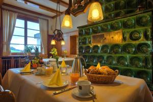einen Tisch mit einem weißen Tischtuch und einem Korb mit Lebensmitteln in der Unterkunft JUFA Hotel Schwarzwald in Lenzkirch