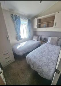 a small bedroom with two beds and a window at Modern Sea View Holiday Home Isle of Wight in Porchfield