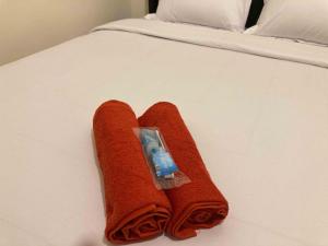 SeturanHartono Inn Seturan Mitra RedDoorz的床上的红色毛巾