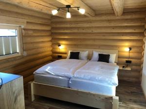- une chambre avec un lit dans une cabane en rondins dans l'établissement Biohof Weiderer, à Lindberg