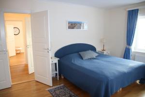 um quarto com uma cama azul e um cobertor azul em Värmvik Gårdskontor em Västervik