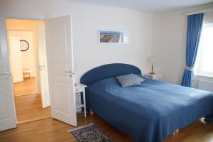 a bedroom with a blue bed with a blue blanket at Värmvik Gårdskontor in Västervik