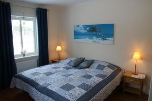 una camera con un letto con una coperta blu e bianca di Värmvik Gårdskontor a Västervik