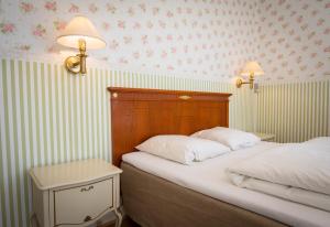 a bedroom with two beds and a wall with flowers at Visborggaard Slots Parkhus in Hadsund