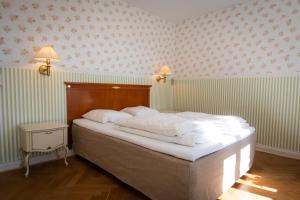 a bedroom with a large bed with white sheets at Visborggaard Slots Parkhus in Hadsund