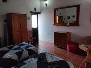 una camera con letto, cassettiera e specchio di la casita de Máguez a Máguez