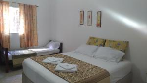 a bedroom with a bed with two towels on it at Pousada Montanha da Pedra Grande in Atibaia